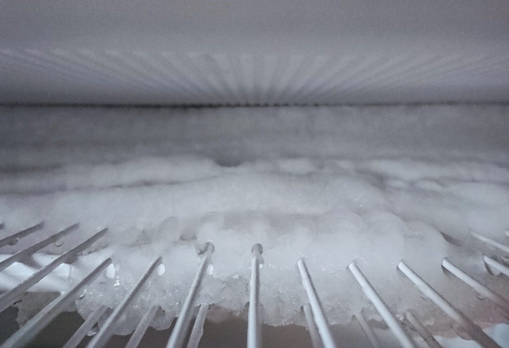 An evaporator grid under a sheet of frost, seen along the shelf